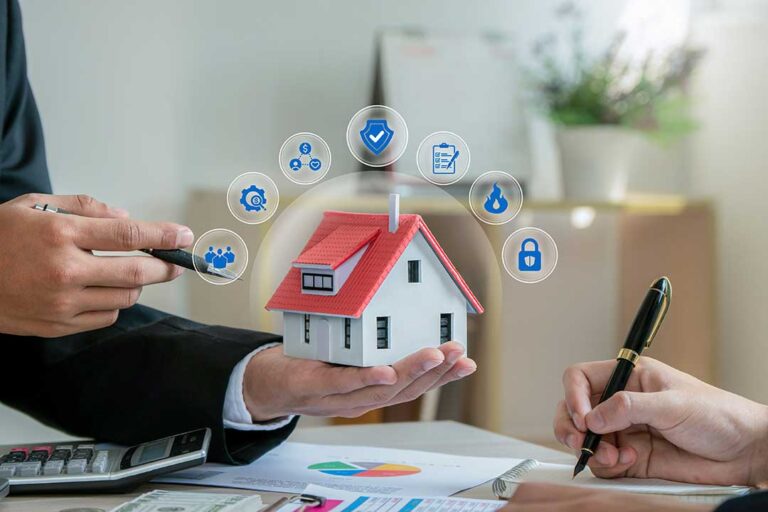 Person reviewing an insurance card beside a smartphone, vehicle keys, and policy papers on a table.